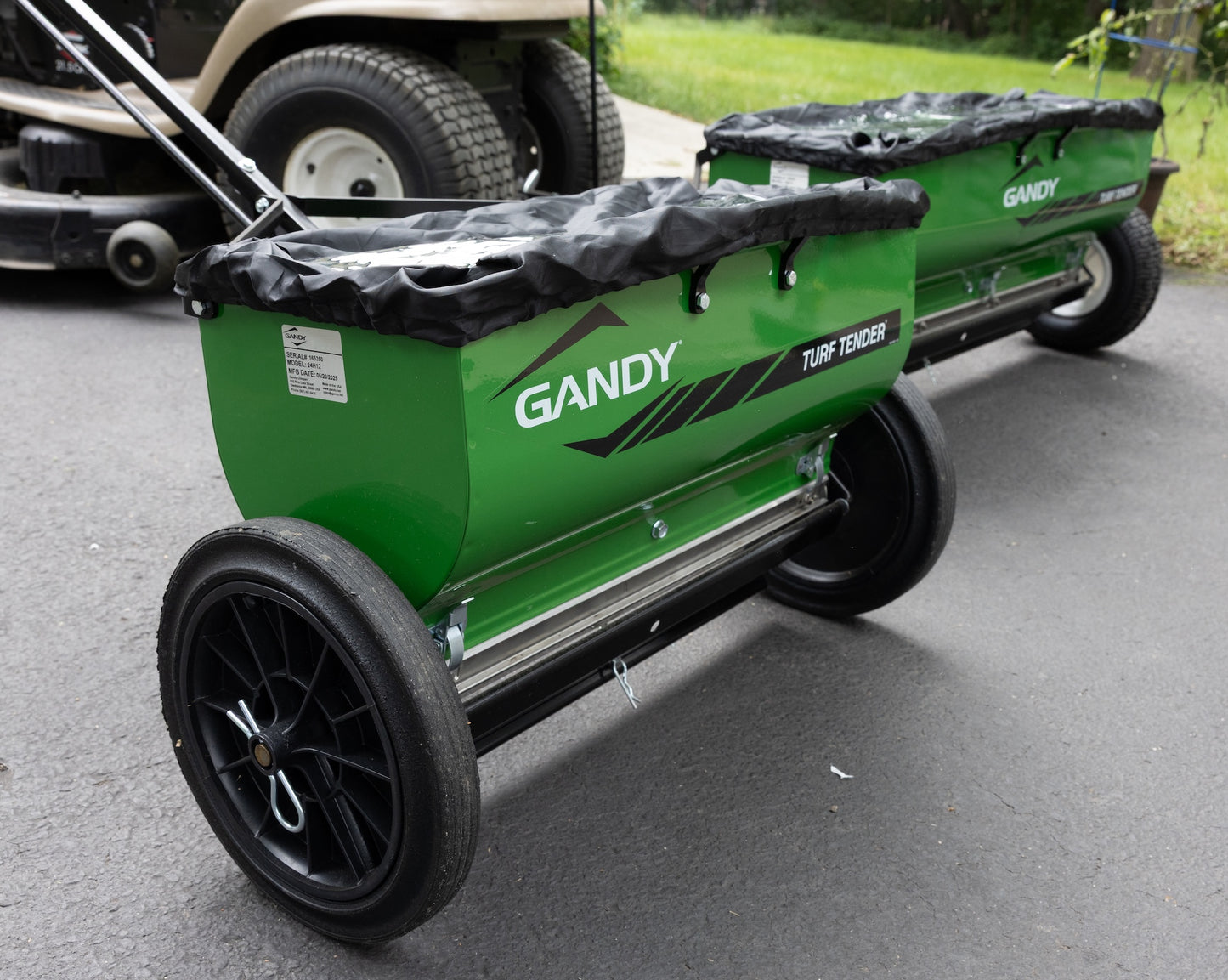 Transparent plastic covers with elastic black edges over hoppers of drop spreaders.